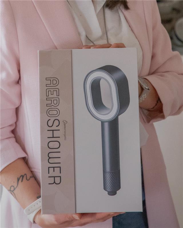 Frau hält AERO Shower Produktbox in den Händen