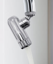 AERO Vital Wasserhahnaufsatz aus verchromtem Metall mit fließendem Wasser, montiert an einem Küchenwasserhahn in Nahaufnahme