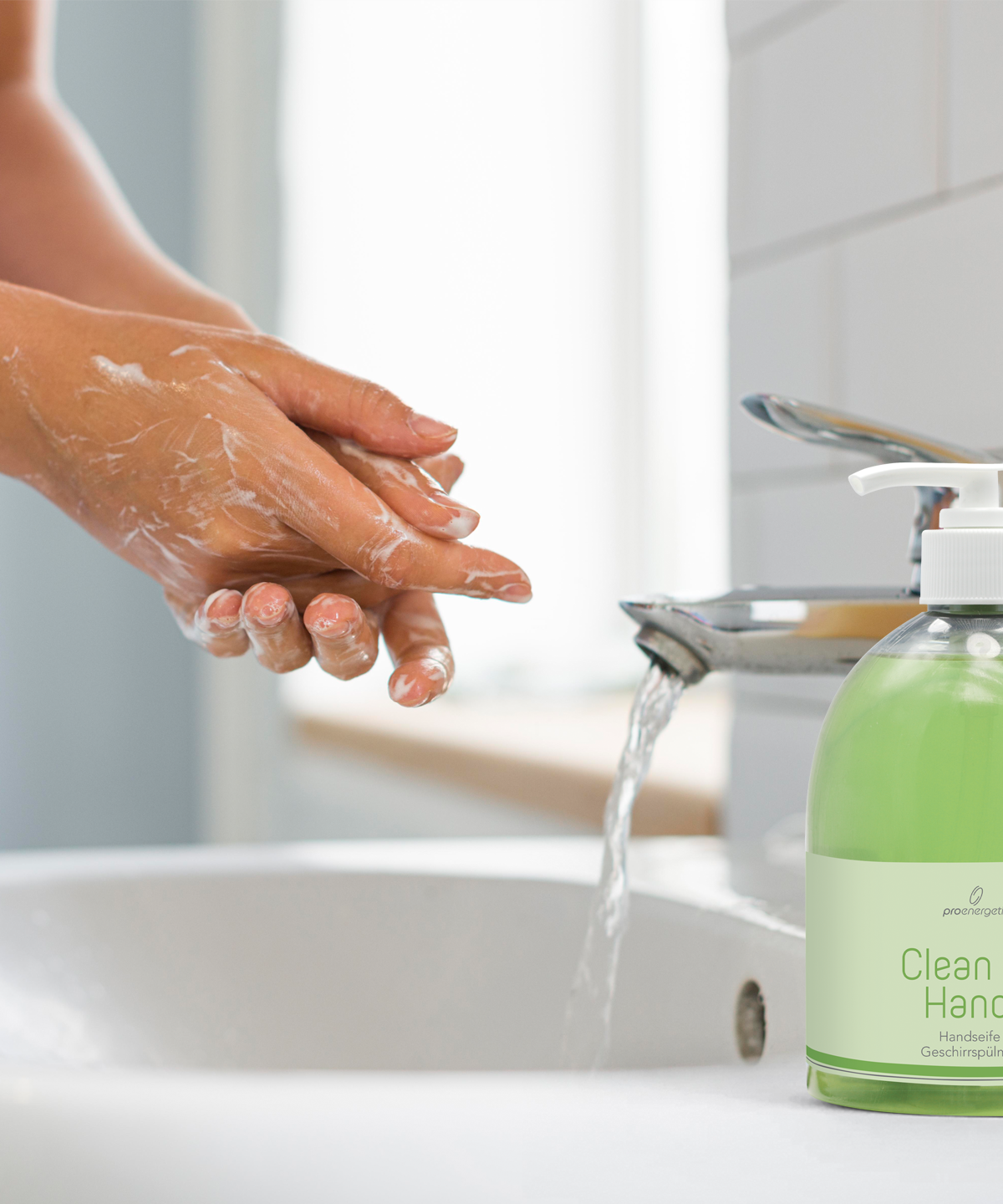 Hände werden an einem Waschbecken mit Clean my Hands Seife gewaschen, die grüne Pumpflasche steht neben dem Wasserhahn