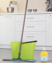 Boden wird mit Wischmopp gereinigt, daneben stehen ein grüner Putzeimer und die Clean my Home Pumpflasche in einer Küche