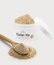 Offener CollaVita-Pulvertiegel mit beigefarbenem Pulver; davor ein Holzlöffel mit CollaVita-Pulver auf hellem, neutralem Hintergrund.
