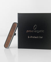 ProEnergetic E-Protect Car Gerät mit Holzfront und Metallgehäuse neben schwarzer Produktverpackung mit Logo und Produktname sichtbar
