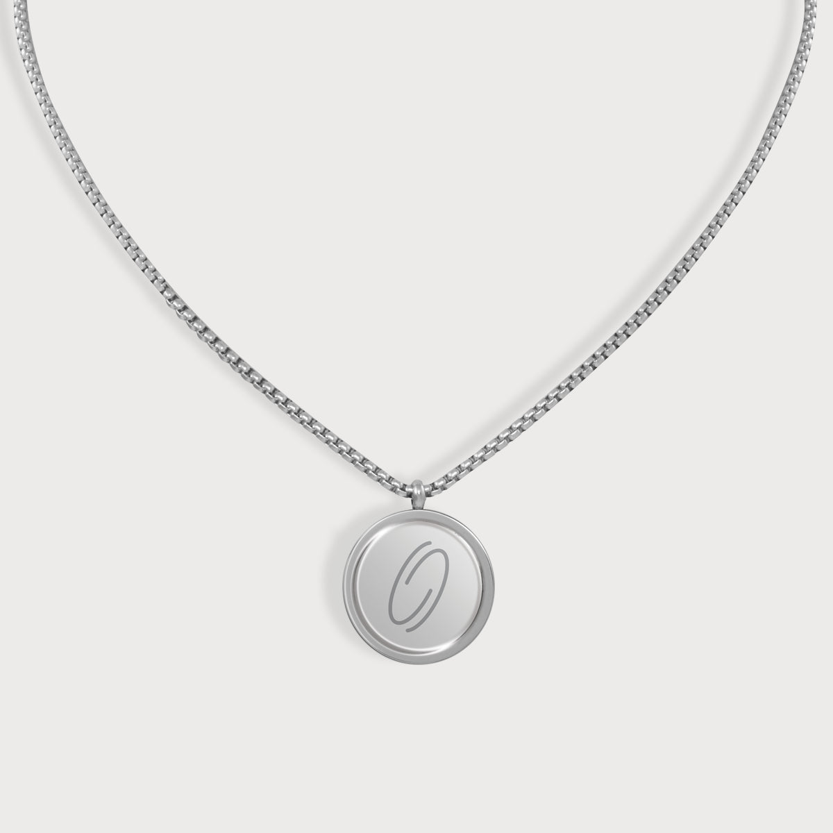 Silberfarbene E-Protect Necklace Halskette von ProEnergetic mit rundem Anhänger und blauem Punkt auf hellem Hintergrund.