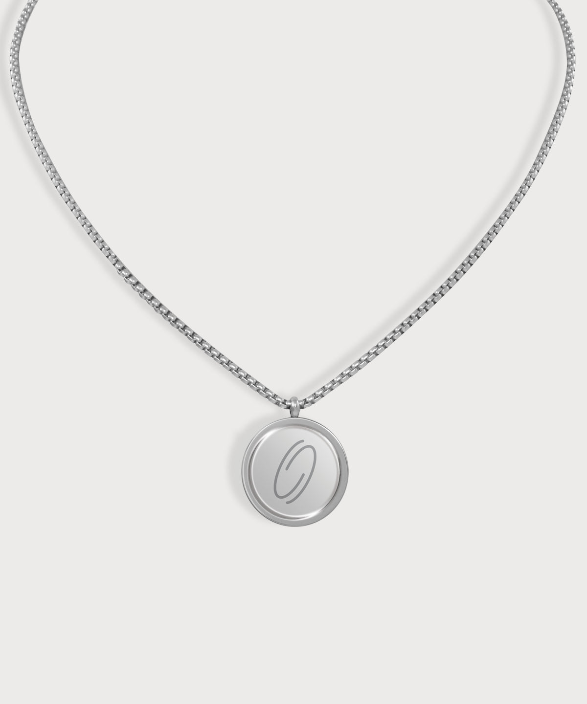 Silberfarbene E-Protect Necklace Halskette von ProEnergetic mit rundem Anhänger und blauem Punkt auf hellem Hintergrund.