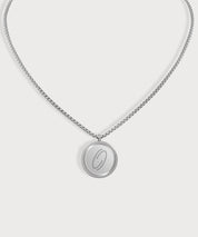 Silberfarbene E-Protect Necklace Halskette von ProEnergetic mit rundem Anhänger und blauem Punkt auf hellem Hintergrund.