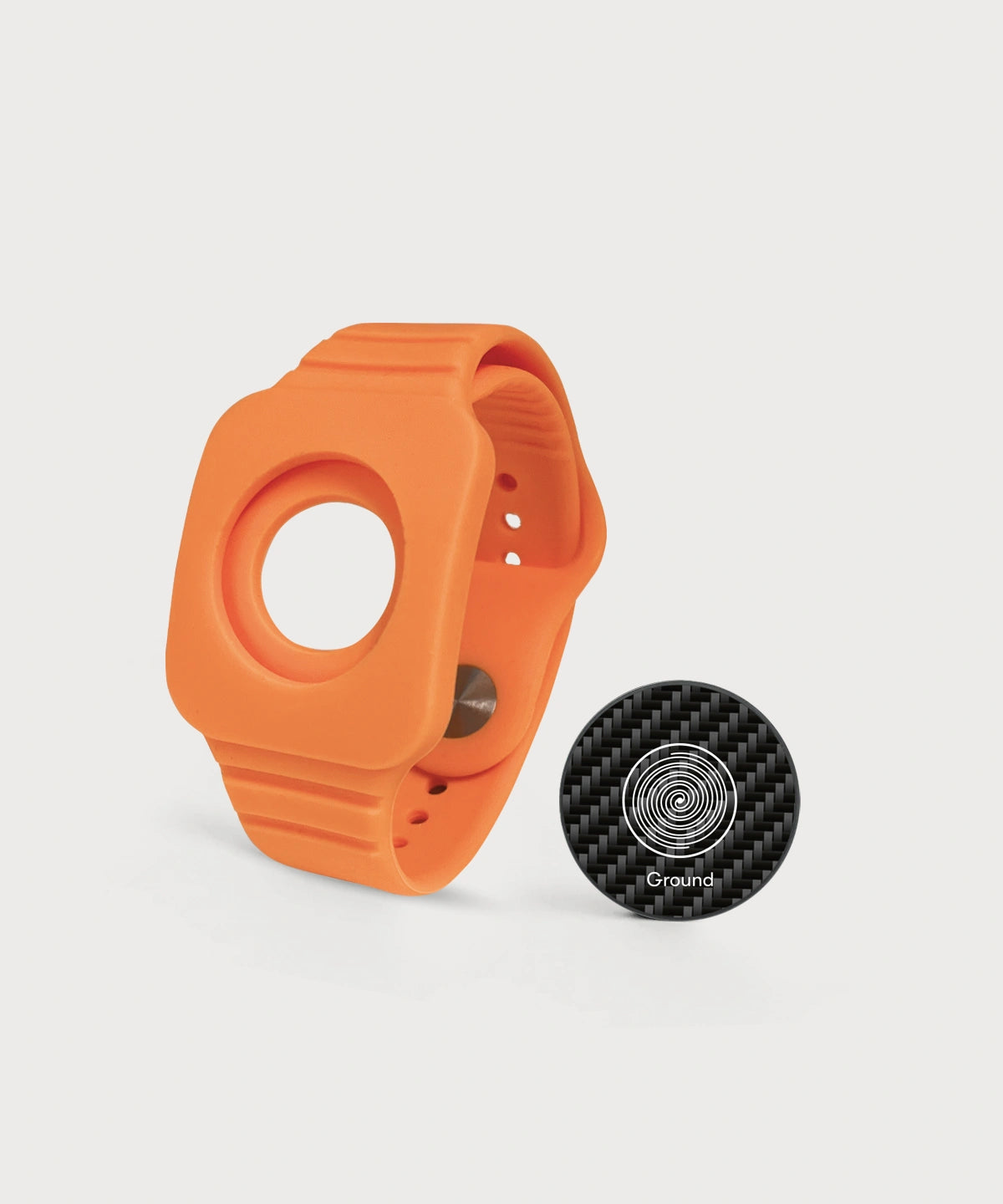 Modulares orangefarbenes Eloop Band mit einem austauschbaren Carbon-Chip mit der Variante "Ground" auf hellem Hintergrund.