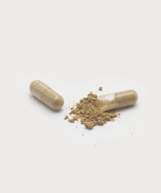 Zwei geöffnete „Essentials Caps“ Kapseln, eine mit herausrieselndem, beigefarbenem Pulver, freigestellt vor hellem Hintergrund.