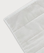 Detailansicht des Grounding Relax Pad mit weißer Textiloberfläche und fein gearbeiteten Nähten auf hellem Hintergrund