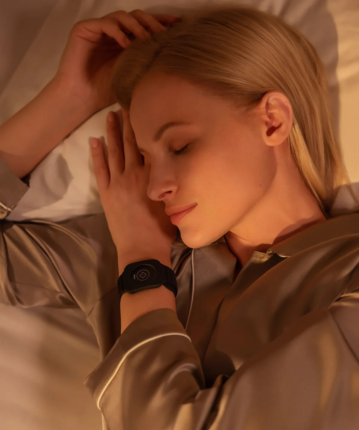 Person liegt im Bett auf der Seite und schläft ruhig auf einer Grounding Sleep Mat, die unter dem Bettlaken positioniert ist