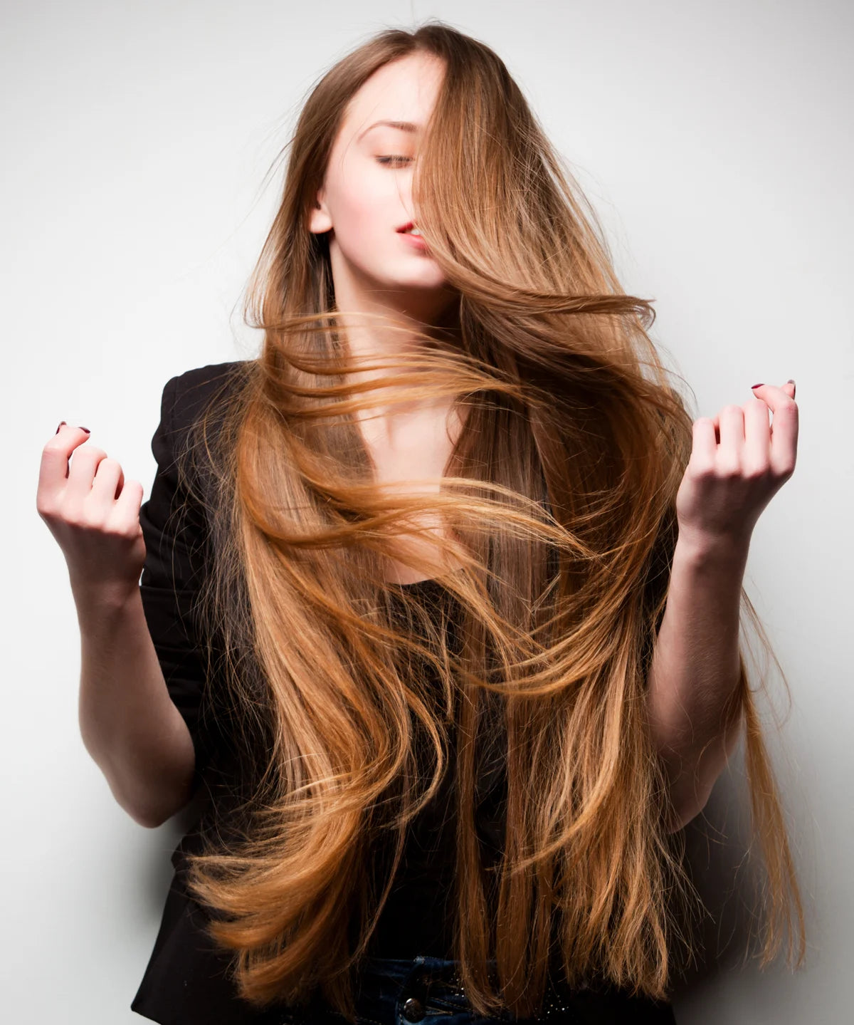 Frau mit langem, glänzendem, geschmeidig fallendem Haar – als visuelle Inszenierung der pflegenden und glättenden Wirkung des Hair Conditioners.