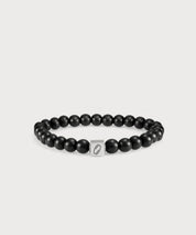 Black “I AM” Energy Bracelet with matte beads and a silver-colored logo element on a light-colored background