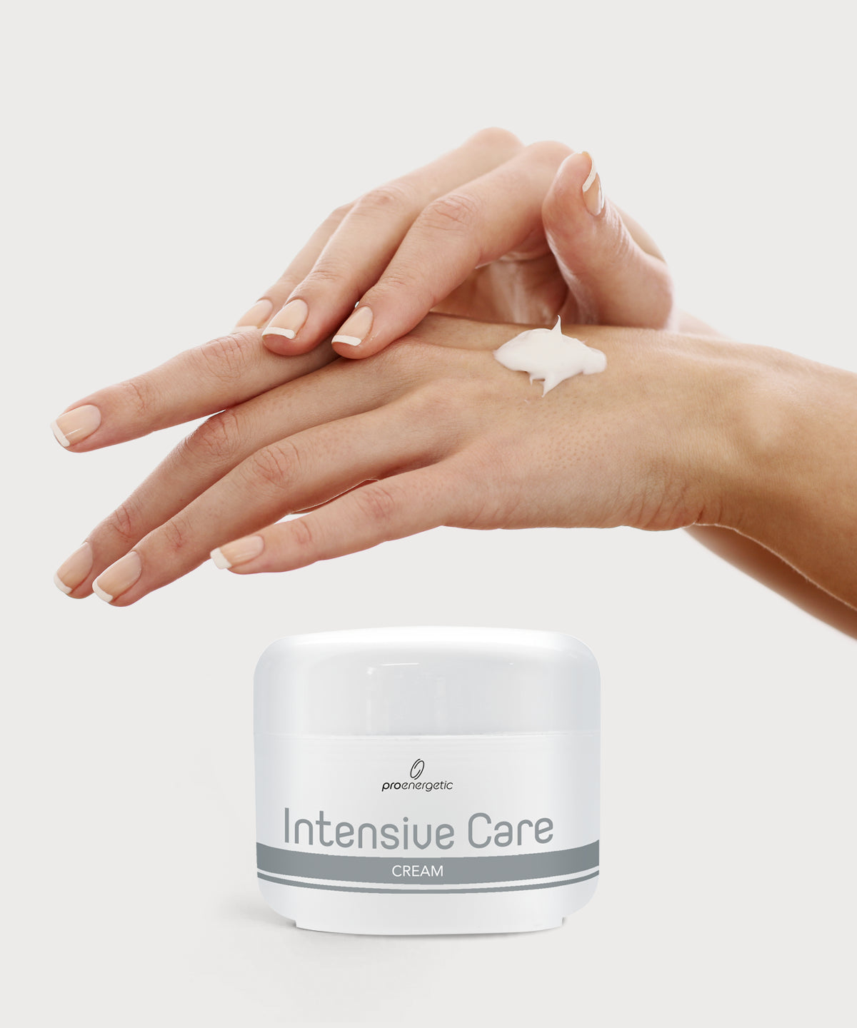 Hände mit weißer Creme auf dem Handrücken über Tiegel Intensive Care Cream vor hellem Hintergrund.