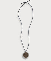 ProEnergetic KIER Protect Necklace mit schwarzem Lederband und rundem Anhänger aus Metall mit sichtbarer Holzscheibe und konzentrischem Linienmuster