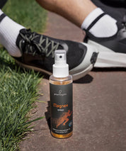 ProEnergetic Magnex Spray standing beside running shoes on a park path, highlighting its use before or after exercise.