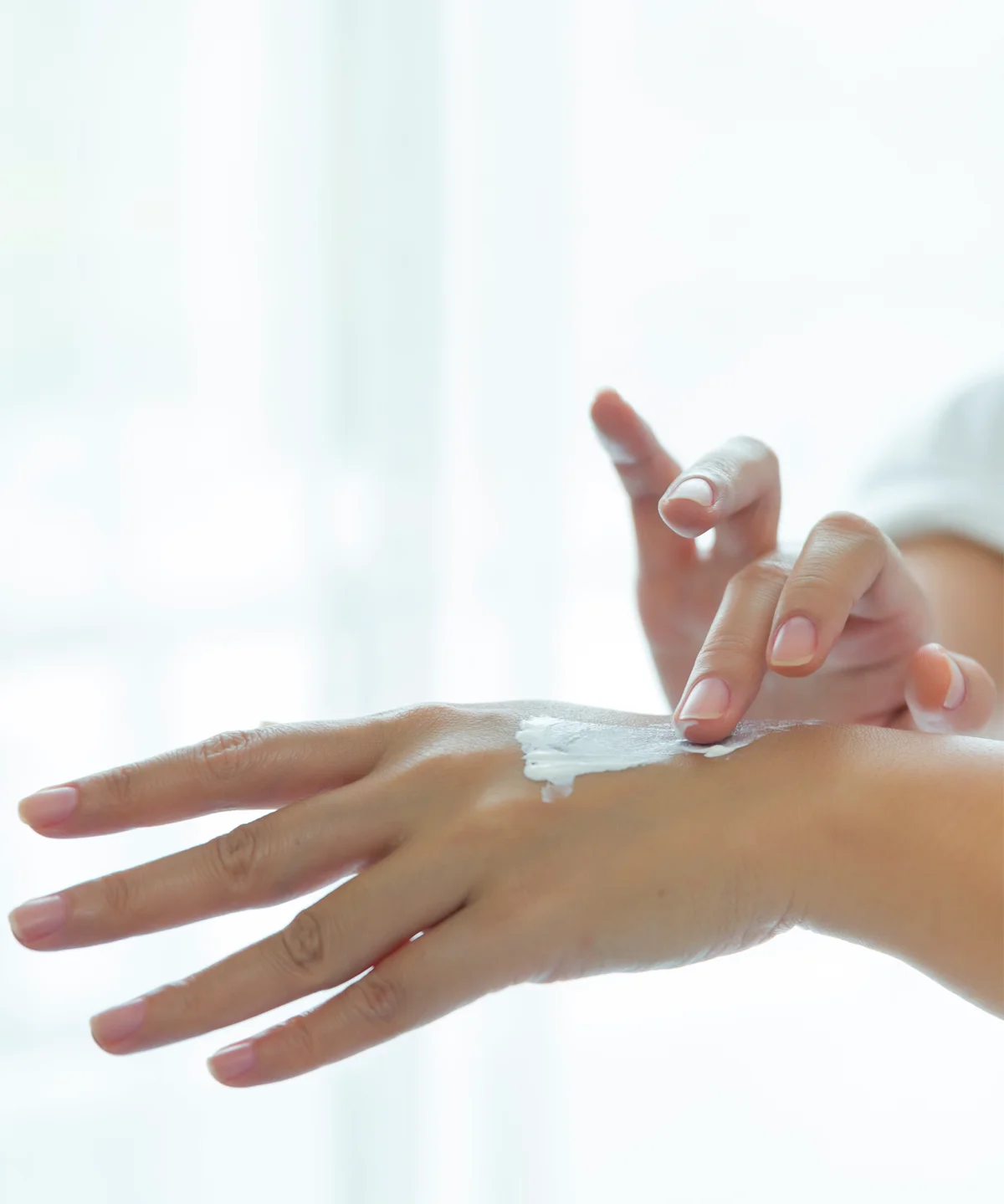Nahaufnahme gepflegter Hände, während der Pretty Hands & Feet Balm sanft auf dem Handrücken aufgetragen und gleichmäßig einmassiert wird – für geschmeidige, intensiv gepflegte Haut.