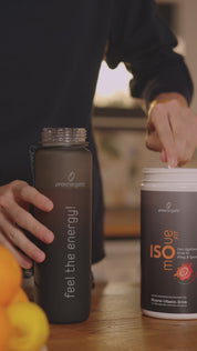 Hände eines Mannes geben einen Messlöffel ISOmove Fit-Pulver in eine Trinkflasche. Das Pulver rieselt ins Wasser; daneben steht die ISOmove-Fit-Dose. Das Video zeigt die einfache Zubereitung und Anwendung des Mineral-Vitamin-Drinks.