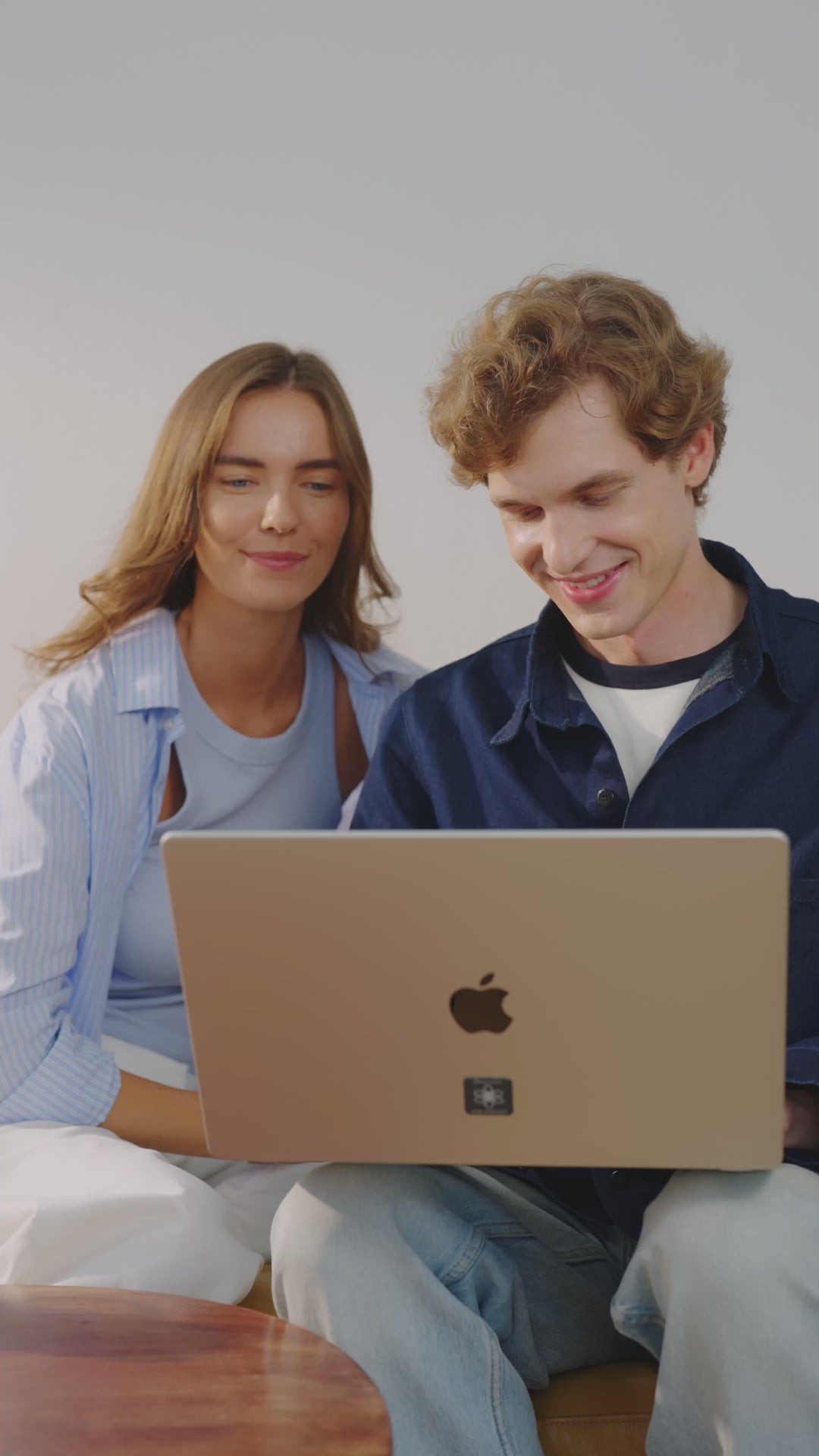 Mann sitzt im Innenraum auf einem Sofa, trägt eine schwarze Smartwatch mit angebrachtem E-Protect Element und legt sich anschließend hin, um zu telefonieren