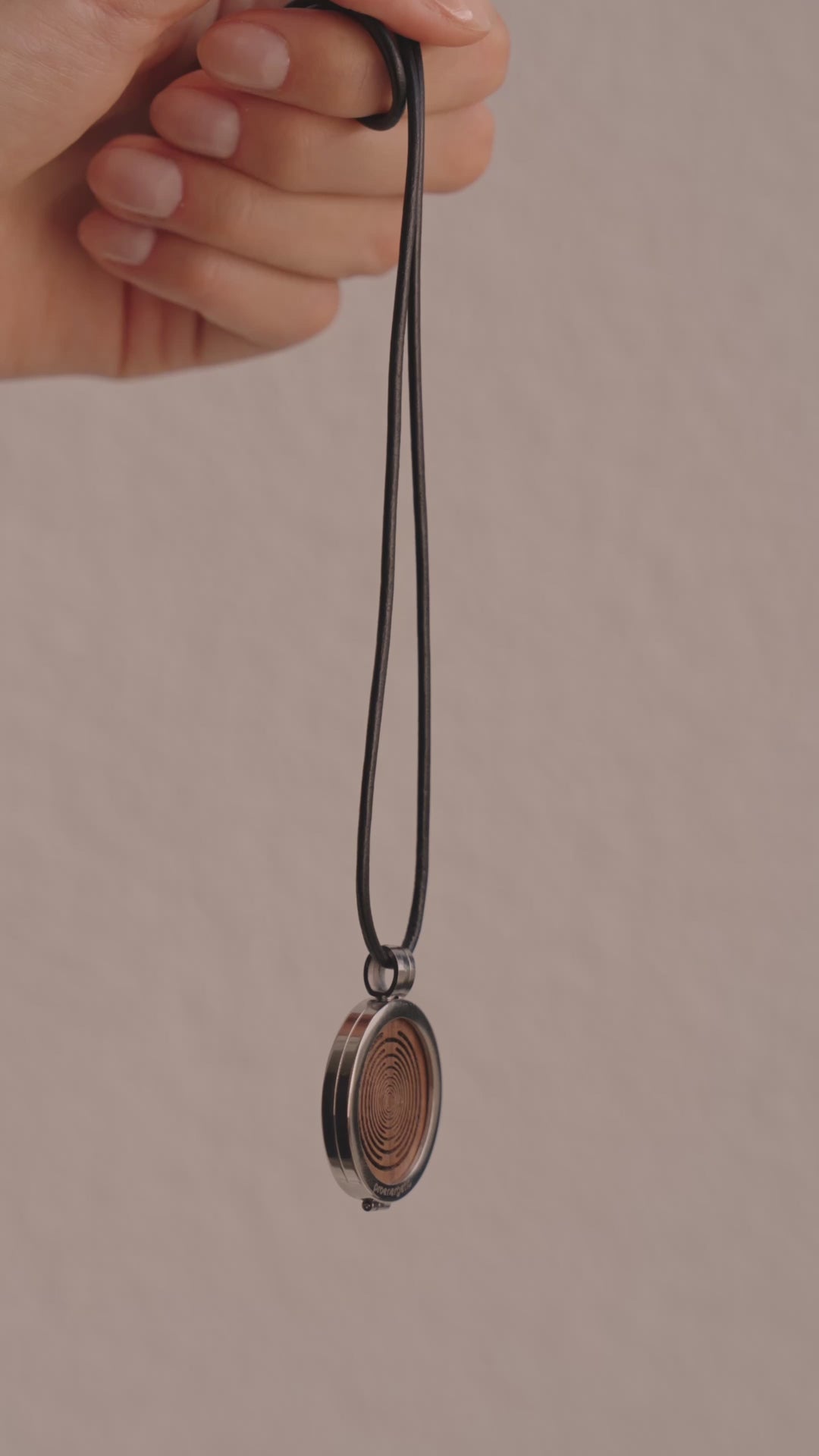 Frau im Innenraum trägt die ProEnergetic KIER Protect Necklace mit schwarzem Lederband und rundem Anhänger sichtbar am Hals