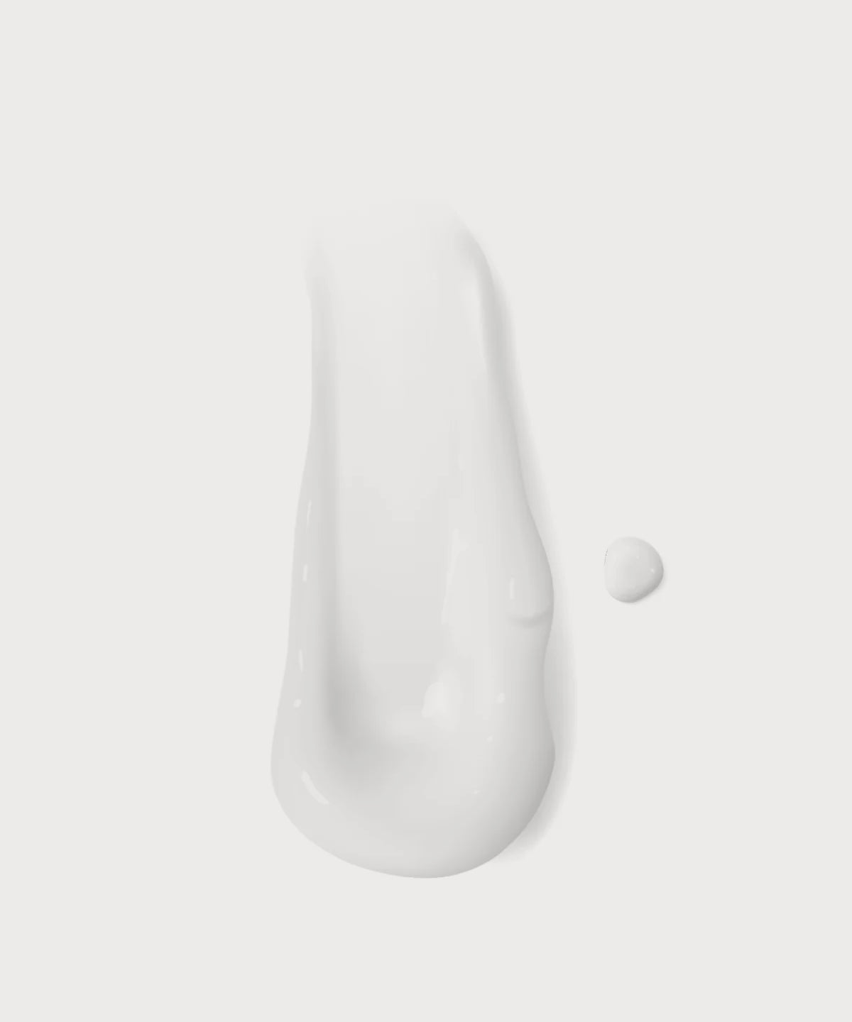 Weiße Cremeprobe in länglicher Form mit kleinem Tropfen auf hellem Hintergrund.
