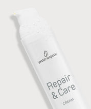 Schräg liegender ProEnergetic Repair & Care Cream Spender mit Wassertropfen auf dem Deckel.