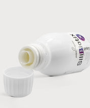 SiliBiotix Liquid von proenergetic: Weiße Flasche liegend mit geöffnetem Ausguss, davor der weiße Schraubdeckel. Leicht gelbliche Flüssigkeit sichtbar im Flaschenhals, neutraler heller Hintergrund.