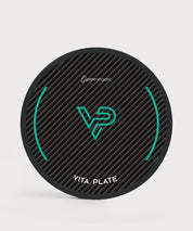 Vita Plate in runder Form mit schwarzer Carbonoptik, türkisfarbenem Symbol und weißem Schriftzug auf hellem Hintergrund