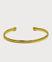 Gold-colored Vitality Bangle with an open design on a light background
